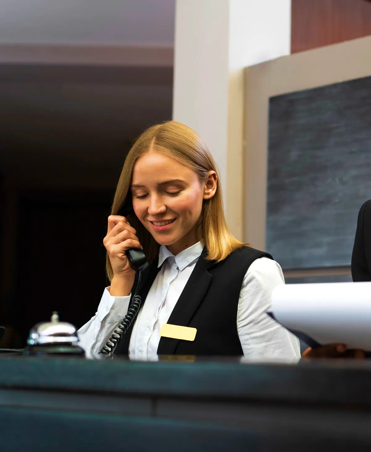 Woman holding a landline phone, responding to customer inquiries, representing dedicated excellent customer support